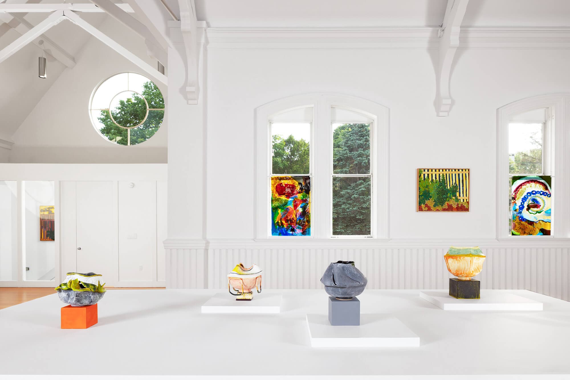 Artworks on display in a white walled deconsecrated Catholic church.
