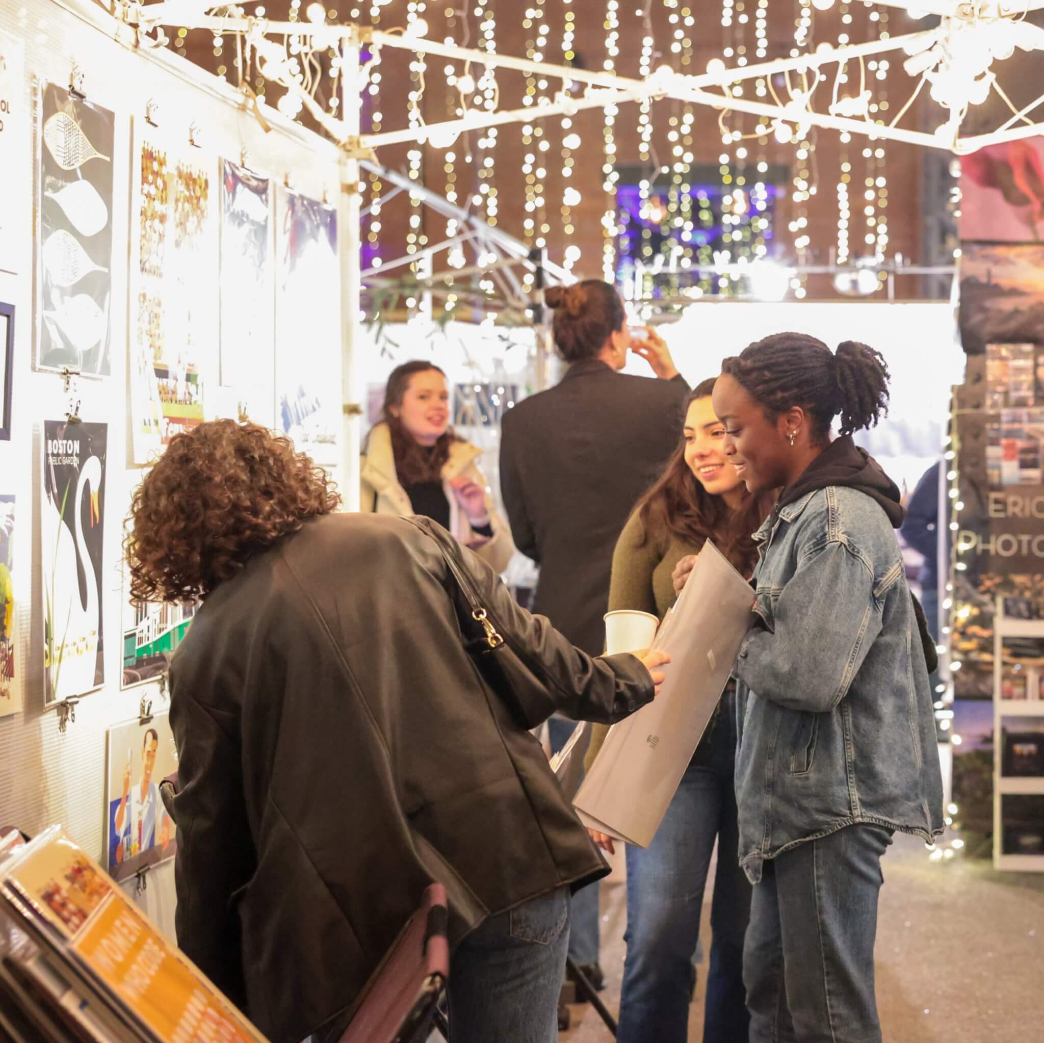 Patrons peruse art at a holiday market.